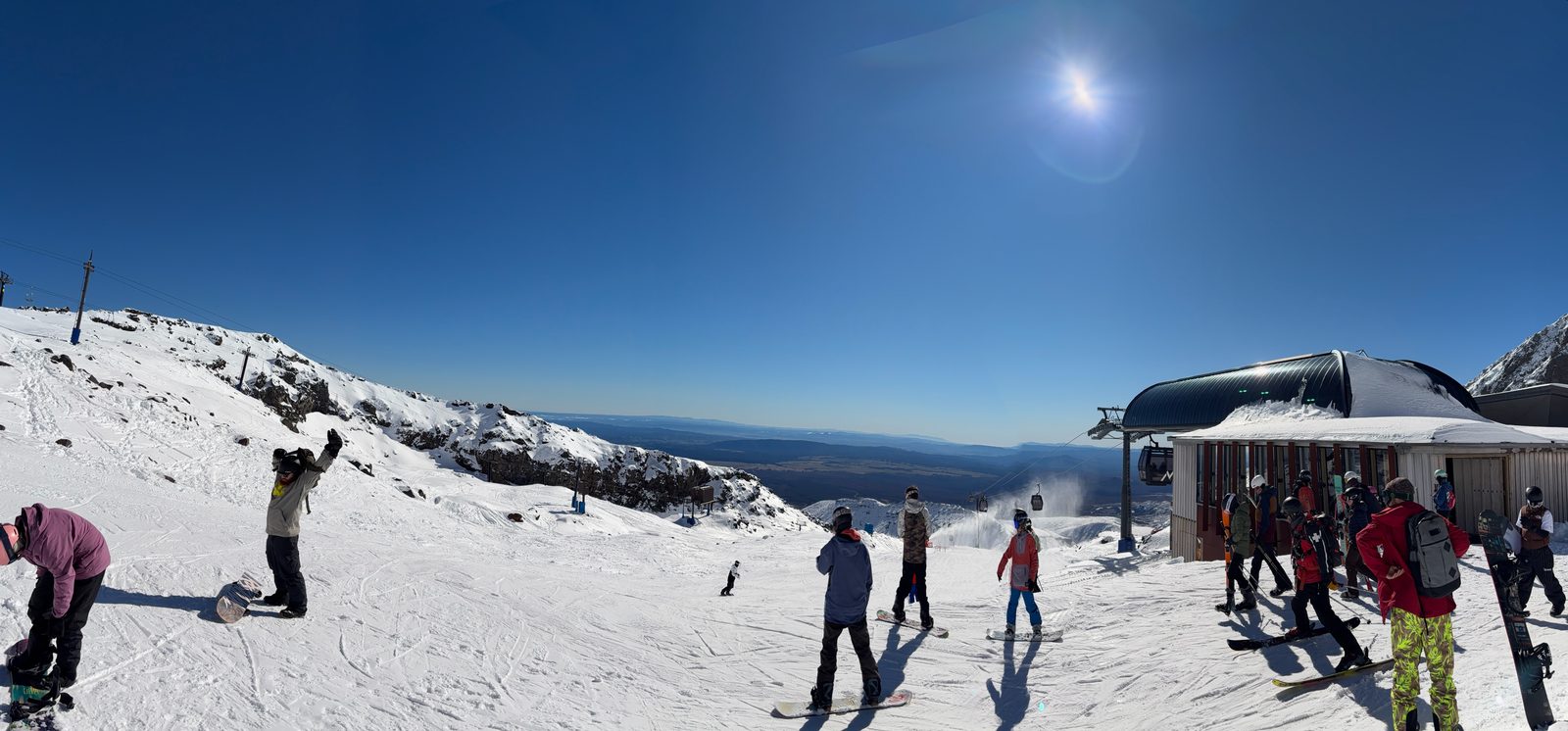Snowboarders and skiers at the gondola station